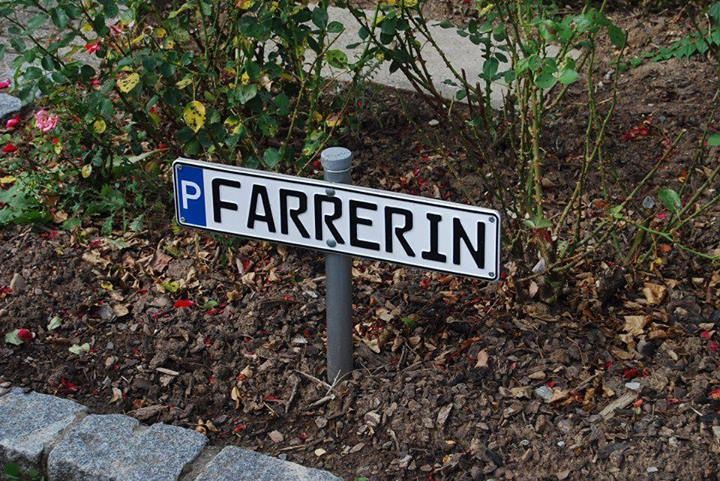 Parkplatzmarkierung mit einem Schild, dass ein großes P auf blauem Grund für Parkplatz hat und dann in schwarzen Buchstaben mit FARRERIN weiter gelesen wird, zusammen also Pfarrerin.